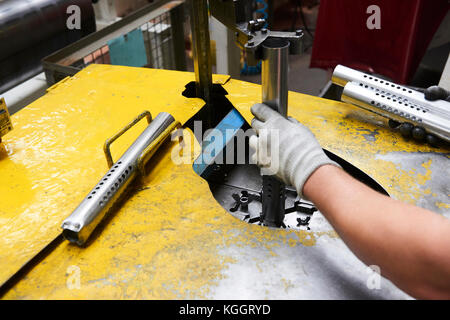 Innerhalb einer Fabrik, Industriearbeiter in Aktion auf Metall Maschine Stockfoto