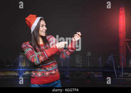 Glücklich lächelnde Frau mit einem imaginären neues Jahr Cracker Stockfoto
