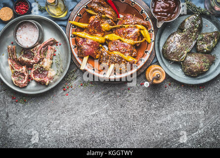 Verschiedene mariniertes Fleisch in Schalen für Grill grillen oder braten mit Gewürzen auf rustikalen Hintergrund, Arten von Fleisch, Ansicht von oben Stockfoto