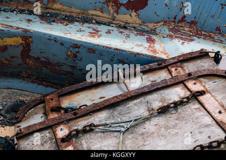 Schließen Sie herauf Foto der Rost und abgenutzt, abblätternde Farbe auf zwei alte ausgemusterter Boote auf dem Kai. Stockfoto