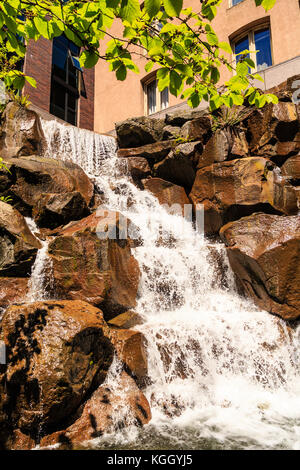 Einen schönen angelegten Wasserfall über Felsen in einem Garten Stockfoto