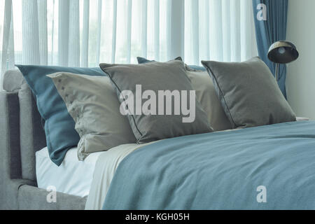 Grauen und blauen Kissen Einstellung auf Bett im tiefen Blau Bettwäsche Stockfoto