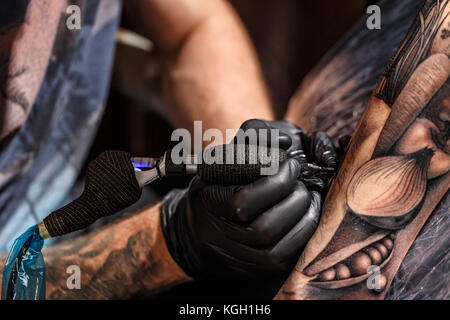 Tattoo Künstler erstellen eine Tätowierung auf dem Arm des Mannes Stockfoto