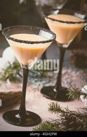 Traditionelle winter Eierlikör in Martini Gläser mit Milch, Rum und Zimt, Weihnachtsschmuck Stockfoto