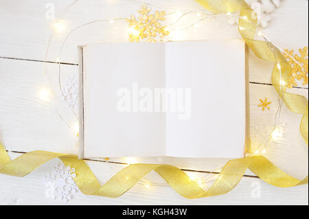 Mockup Weihnachten oder Neujahr frame Komposition. Mockup von Buch und goldene Weihnachten Dekorationen auf Holz- Hintergrund. Urlaub und Feier Konzept für Postkarte oder Einladung. top View Stockfoto