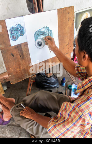 Mann Malerei eine DSLR-Kamera auf einer weißen Leinwand, Streetart, Jakarta, Indonesien Stockfoto