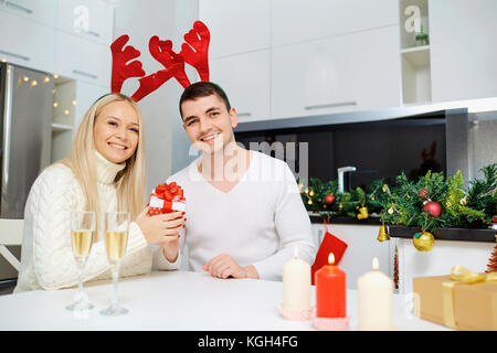 Paar Rentiere Hörner gibt ein Weihnachtsgeschenk. Stockfoto