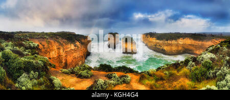 Regenbogen über erodiert Kalkstein Apostel, Loch Ard Gorge der Great Ocean Road zwölf Apostel Marine Park. Stürmisches Regenwetter bringt Rainbow und Stockfoto