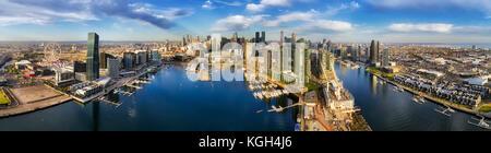 Antenne breites Panorama von Melbourne Docklands über den Fluss Yarra Gewässer mit Marina Yachten und Kaianlagen. Moderne urbane hoch aufragenden Türmen und Architektur Stockfoto