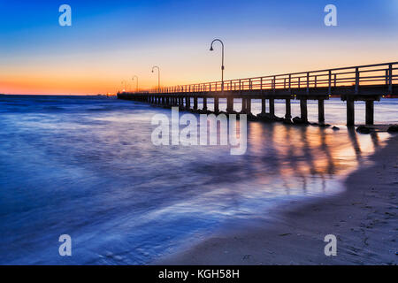 Historischen Fachwerkhäuser Steg zum Angeln und Erholung in Port Philip Bay vor Port Melbourne Sandstrand bei Sonnenuntergang. Stockfoto