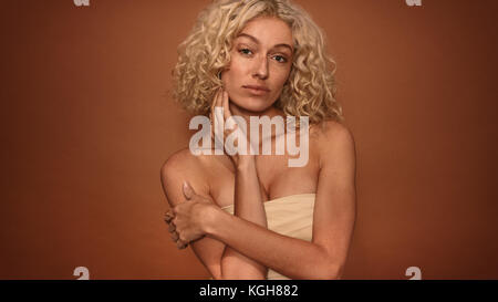 Portrait junge Frau sich gegen braunen Hintergrund. Kaukasische weibliche model in Kamera schaut. Stockfoto