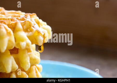 Selektiver Fokus auf einem Stapel von belgischen Waffeln extreme Nahaufnahme Seitenansicht mit einem großen Tropfen Sirup, Schuß für Kopie und Text für Menüs und Re Stockfoto