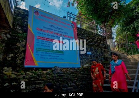 Kathmandu, Nepal - September 04, 2017: nicht identifizierte Frau wandern am Morgen in der Nähe einer informativen Zeichen an im Freien in Kathmandu, Nepal Stockfoto