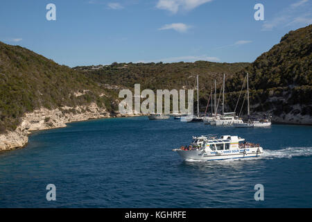 Touristen auf eine Freude, Kreuzfahrt in der Bucht von Bonifaccio mit Yachten im Hintergrund günstig Stockfoto