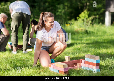 Frau crouching durch Bausteine, während Freunde Planung in Bac Stockfoto