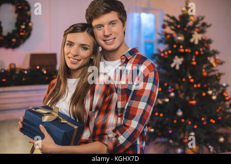 Mann umarmen Freundin mit Weihnachtsgeschenk Stockfoto