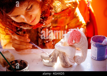 yong Frau macht eine Zwergfigur. Kreatives Konzept. Stockfoto