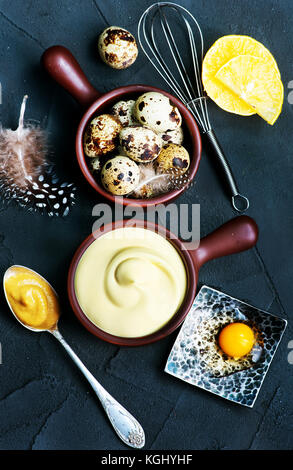 frische Mayonnaise-Sauce in Schüssel geben und auf einem Tisch Stockfoto