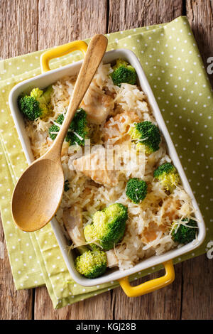 Diätetische Lebensmittel: Reis gebacken mit Brokkoli, Hühnchen und Käse close-up in einer Auflaufform. Senkrechte Draufsicht von oben Stockfoto