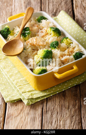 Lecker Reis mit Brokkoli, Hühnchen und Käse close-up in einer Auflaufform auf einem Tisch. Vertikale Stockfoto
