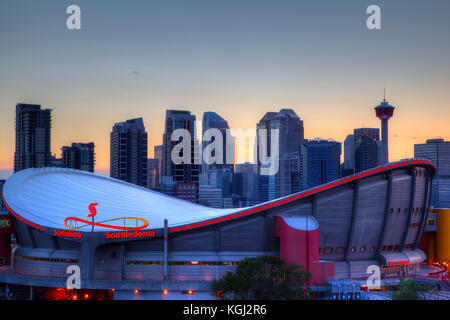 Calgary, Kanada - 23. Mai 2015: Sonnenuntergang über der Skyline von Calgary mit der Scotiabank saddledome im Vordergrund. die Kuppel mit ihrer einzigartigen Sattelform Stockfoto