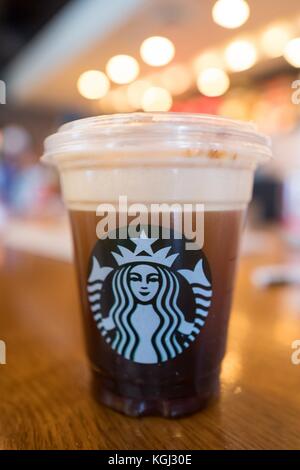 Nahaufnahme eines Nitro Freddo Coffee Drinks, ein Kaltgebrühkaffee von Starbucks, serviert auf Fass mit komprimiertem Stickstoff, mit einem Topping aus kalter Creme und Karamell, eingeführt 2017 auf ausgewählten Märkten, auf einer hellen Holzoberfläche, Silicon Valley, Palo Alto, Kalifornien, 20. September, 2017. () Stockfoto