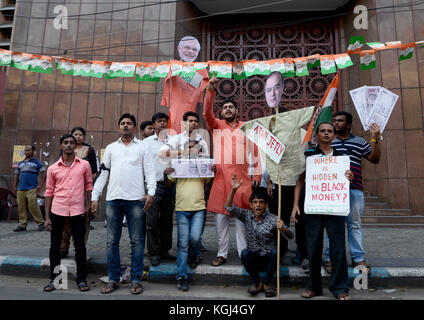 Der Chatra Parishad-Aktivist hält während einer Protestkundgebung vor dem Regionalbüro der Reserve Bank of India in Kalkutta ein Plakat, eine Kopie der Banknote und ein Bildnis von Premierminister Narendra Modi und einen Slogan gegen die Regierung der Union. Der Studentenflügel des Kongresses Chatra Parishad protestiert aktivistisch gegen den Studentenflügel des Kongresses Chatra Parishad protestiert aktivistisch gegen die Regierung der Union anlässlich des ersten Jahrestages der Verteufelung der Banknote vor dem Regionalbüro der Reserve Bank of India am 8. November 2017 in Kalkutta. Die Unionsregierung dämonisierte am 8. November 20 die Banknoten 500 und 1000 Rs Stockfoto