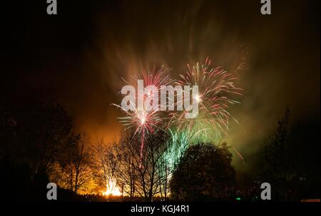 Feuerwerk über Bäume mit Lagerfeuer am heiligen Herzen Grundschule, Bushey, Hertfordshire, Großbritannien Stockfoto