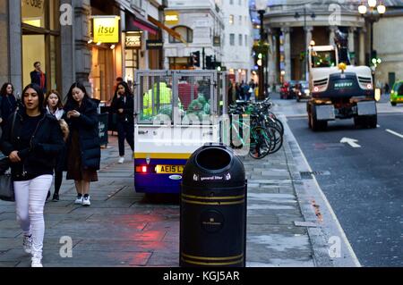 Binman mit motorisierten Wagen sammeln Müllsäcke aus Behälter, Regent Street, London, UK Stockfoto