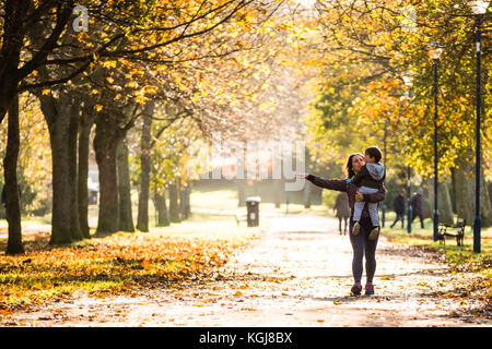 Aberystwyth Wales Großbritannien, Mittwoch 08 November 2017 Großbritannien Wetter: Menschen, die an einem hellen, sonnigen, aber frostigen Morgen den von Bäumen gesäumten Plascrug Avenue Park in Aberystwyth Wales entlang spazieren Kredit: keith morris/Alamy Live Nachrichten Stockfoto