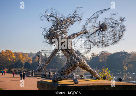 Wishes, eine lebensgroße Draht-Löwenzahn-Kunstskulptur in Stoke-on-Trent. Wetter in Großbritannien. November 2017. Hell sonniger Start in den Tag in Trentham Gardens, Wäldern und Parks. In den Trentham Gardens befindet sich der meilenlange, von Capability Brown gestaltete Trentham Lake mit einem Rundgang am See entlang des Flusses Trent. Stockfoto