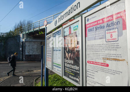 Manchester, Großbritannien. 08 Nov, 2017. Ein Fußgänger überquert die Straße im Winter licht Vergangenheit signage an Mauldeth Road Railway Station, Burnage, Manchester. Die Beschilderung gibt Auskunft über die Verwendung der Eisenbahn am Mittwoch, den 8. November wegen der Streiks, die von den Mitgliedern der RMT-Union. Quelle: Matthew Wilkinson/Alamy leben Nachrichten Stockfoto