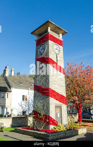 Der Glockenturm Kriegerdenkmal in der Mitte des Cotswold Stadt Nailsworth ist mit 7.000 gestrickte Roter Mohn Erinnerung Sonntag zu gedenken geschmückt. Stockfoto