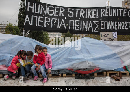 Athen, Griechenland. November 2017. Flüchtlingskinder sitzen an ihren Zelten auf dem Syntagma-Platz im Zentrum von Athen, Griechenland, 08. November 2017. Am 1. November 2017 versammelten sich Flüchtlinge - hauptsächlich aus Syrien - auf dem Syntagma-Platz in Athen, gegenüber dem griechischen Parlament, die eine Protestsitzung und einen Hungerstreik begannen und die griechische und deutsche Regierung aufforderten, die sechs Monate gesetzliche Grenze für Familienzusammenführungen einzuhalten und die Wiedervereinigung mit ihren Familien in Deutschland zu ermöglichen. Quelle: dpa Picture Alliance/Alamy Live News Stockfoto