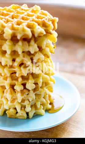 Selektiver Fokus auf einem hohen Stapel von belgischen Waffeln vertikale Seitenansicht mit Tropfen Sirup, Sonnenlicht reflektieren Schuß für Kopie und Text für m Stockfoto