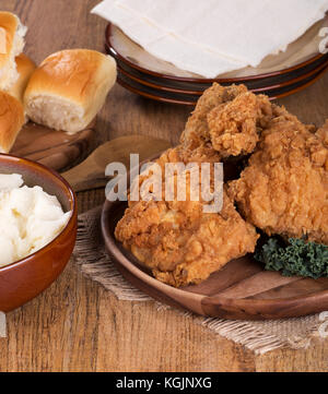 Gebratenes Huhn auf einer Servierplatte mit Kartoffelpüree und Rollen Stockfoto