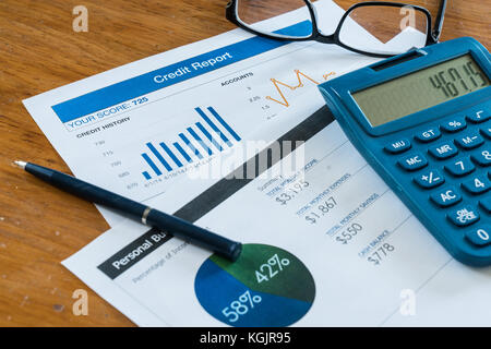 Credit Score Report auf dem Schreibtisch mit dem Budget, Taschenrechner, Stift und Gläser Stockfoto