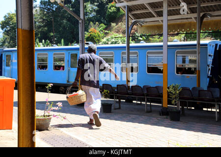 Junction Station Peradeniya Kandy Zentralprovinz Sri Lanka Mann Tragekorb hetzen Zug zu bekommen Stockfoto