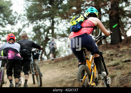 Horizontale Foto eines weiblichen Rider Klettern ein Schritt klettern Sie auf Ihrem Mountainbike während eines Rennens Stockfoto