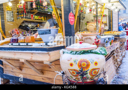 KIEW, UKRAINE - 4. JANUAR 2017: Großer, schöner Keramiktopf mit Handmalerei und heißem Glühwein steht am Imbissstand auf der Weihnachtsmesse Stockfoto