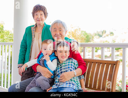 Senior nach chinesischen Paar mit ihren gemischten Rennen Enkelkinder Stockfoto