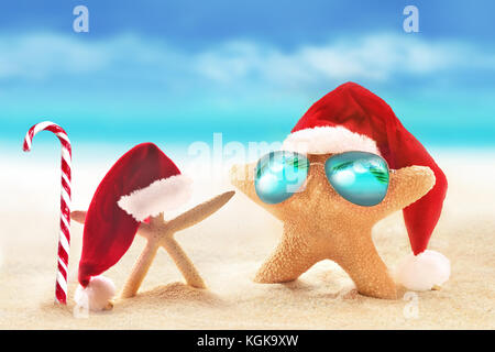 Seesterne in Sonnenbrille auf Sommer Strand und Santa hat. Weihnachten. Stockfoto