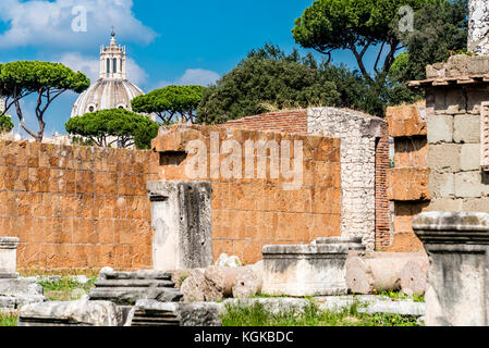 Bleibt der Basilica Aemilia, Forum Romanum, Rom, Italien. Antike römische Tempel Ruinen, barocke Kirche im Hintergrund. Stockfoto