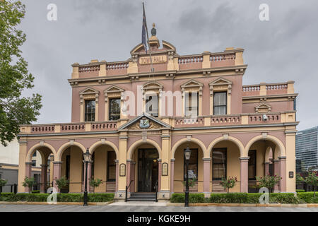 Parramatta, Australien - März 24, 2017: Braun historischen Rathaus unter schweren regnerischen Himmel. Laternen und grüne Vegetation herum. Stockfoto