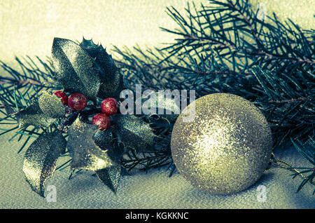 Golden Weihnachtskugel und roten Holly Stockfoto