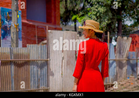 Kathmandu, Nepal Oktober 15, 2017: Unbekannter nepalesische Frau im roten Kleid und einem Hut mit Sonnenbrille im Kopf, für die Kamera posieren, in einem Durbar Square in einem beautidul sonnigen Tag in der Nähe von Alte hinduistische Tempel in Kathmandu, Nepal Stockfoto