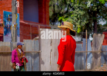 Kathmandu, Nepal Oktober 15, 2017: Unbekannter nepalesische Frau im roten Kleid und einem Hut mit Sonnenbrille im Kopf, für die Kamera posieren, in einem Durbar Square in einem beautidul sonnigen Tag in der Nähe von Alte hinduistische Tempel in Kathmandu, Nepal Stockfoto