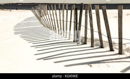 Schnee Strand mit Zaun und Schatten. Stockfoto