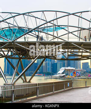 Singapur - Jan 14, 2107: die Menschen gehen, die von Helix Bridge in Singapur. Die Helix von 650 Tonnen Duplex Edelstahl und 1000 hergestellt ist Stockfoto