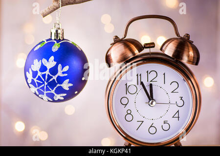 Vintage Kupfer Wecker mit fünf Minuten bis Mitternacht. Silvester Countdown. blue christmas tree Ball mit Ornament hängend an Zweig. glitzernden Stockfoto